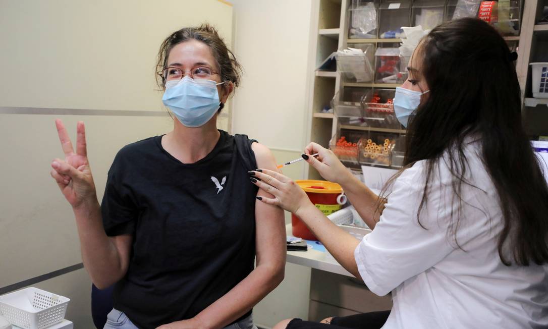 94918265 FILE PHOTO An Israeli woman poses for a picture as she receives a third shot of coronav